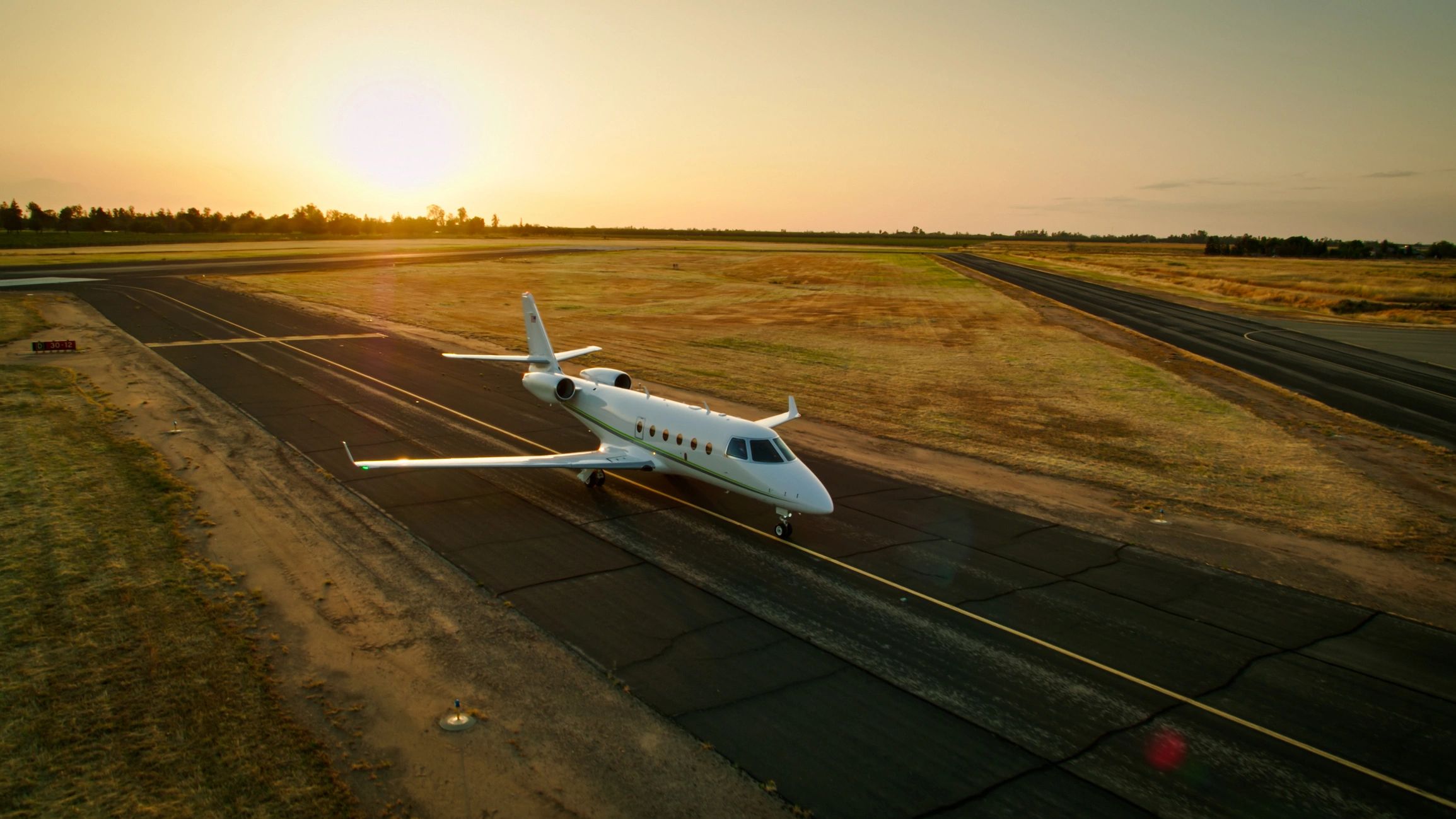 Private jet on tarmac at sunset